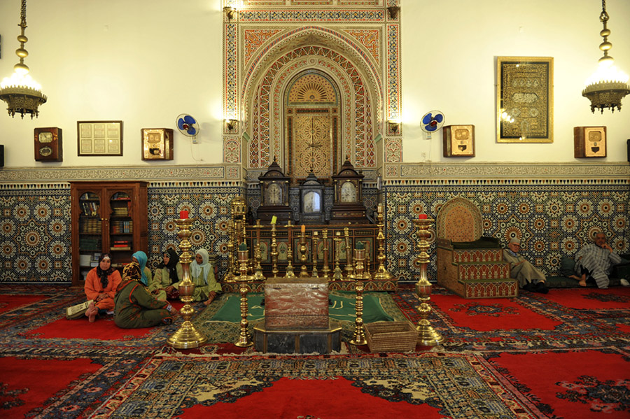 In the hope to gain good fortune, visitors who have made offerings sit by the tomb of the great saint Abou-l-Abbes Sebti, Zaouia Sidi Bel Abbes, Marrakech, 2011